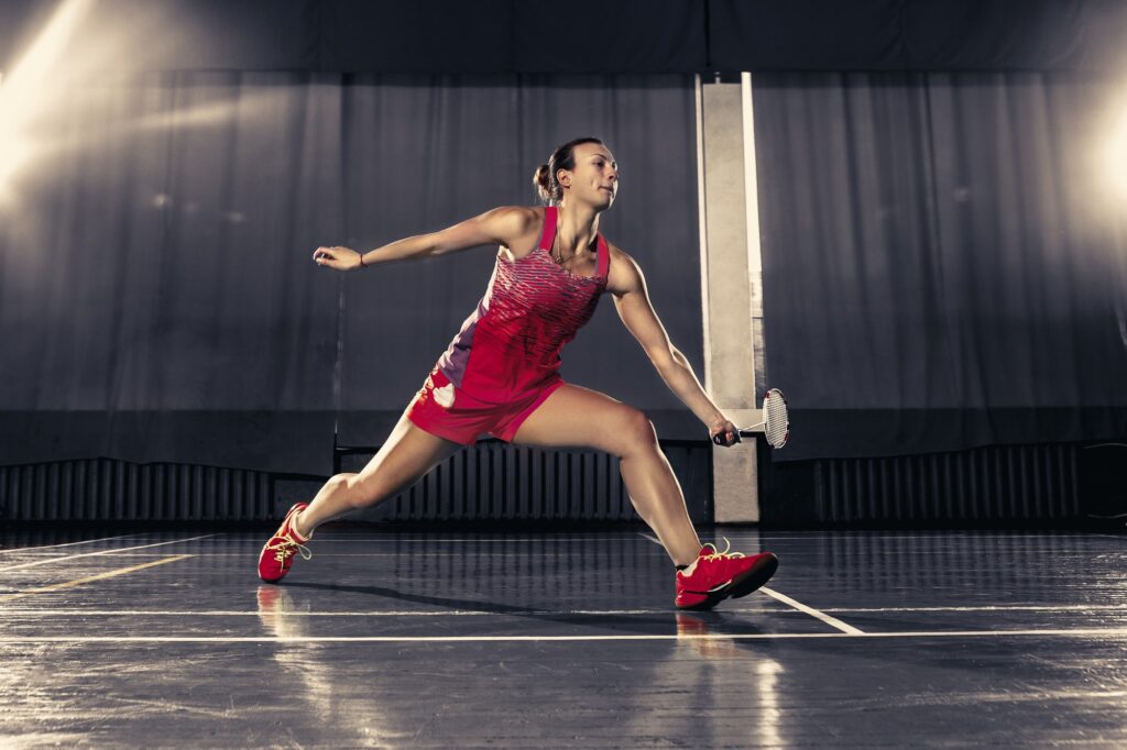 Young woman playing badminton at gym.jpg